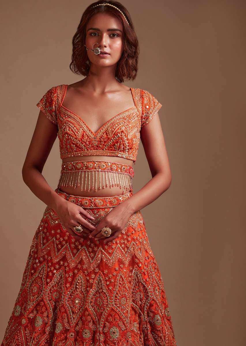 Coral Orange Lehenga Choli In Net With Mirror And Sequins Embroidered Floral And Mughal Embroidery Along With Belt Detailing