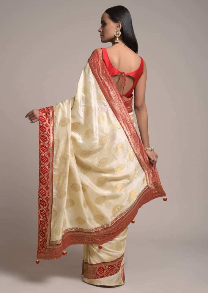 Off White Saree In Dola Silk With Brocade Leaf Shaped Buttis And Contrast Red Bandhani Border