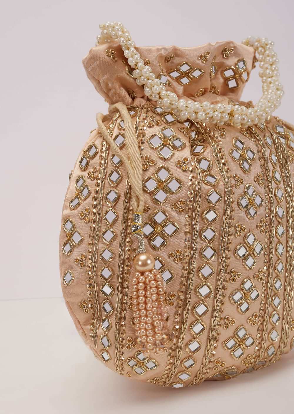 Powder Peach Potli In Satin With Hand Embroidery Detailing Using Mirror And Zardosi In Geometric Design