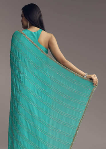 Turquoise Blue Embroidered Chinon Saree With Wavy Border